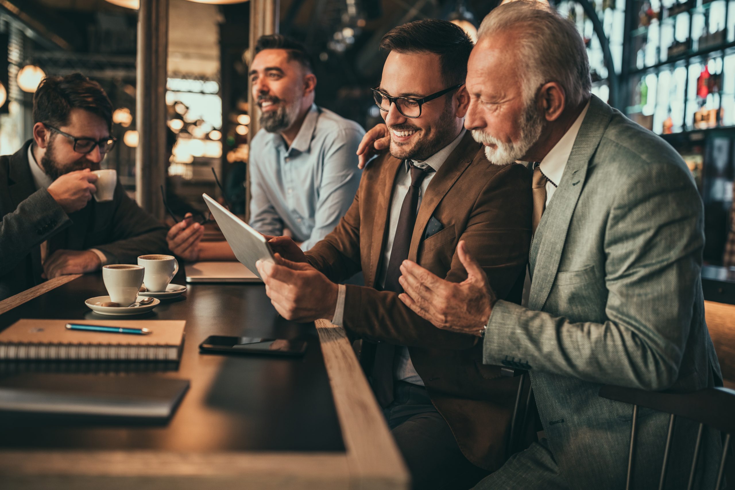 Team of colleague talking about new project and using technology in the pub