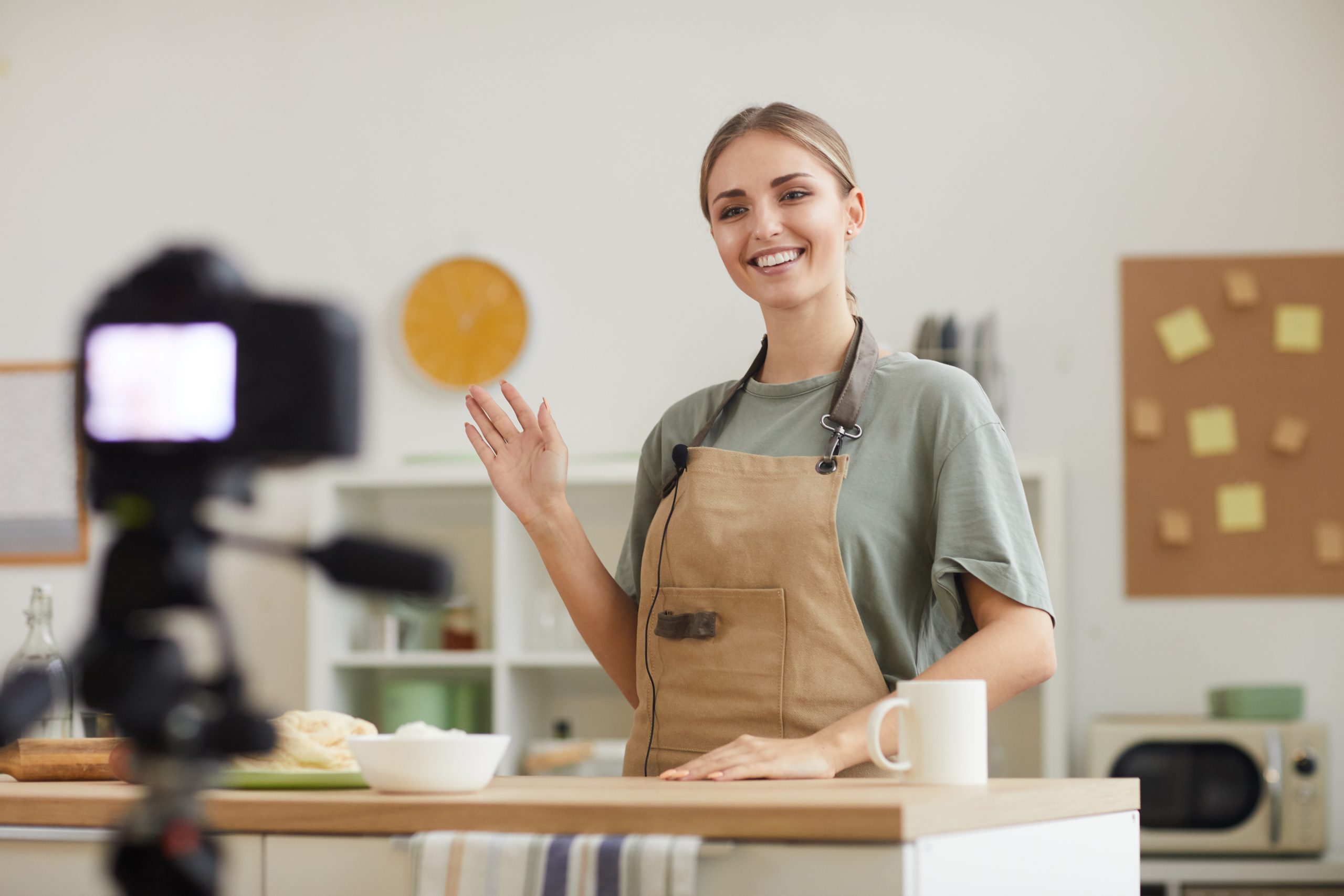 Young blogger smiling at camera and shooting the video she teaching to cook online