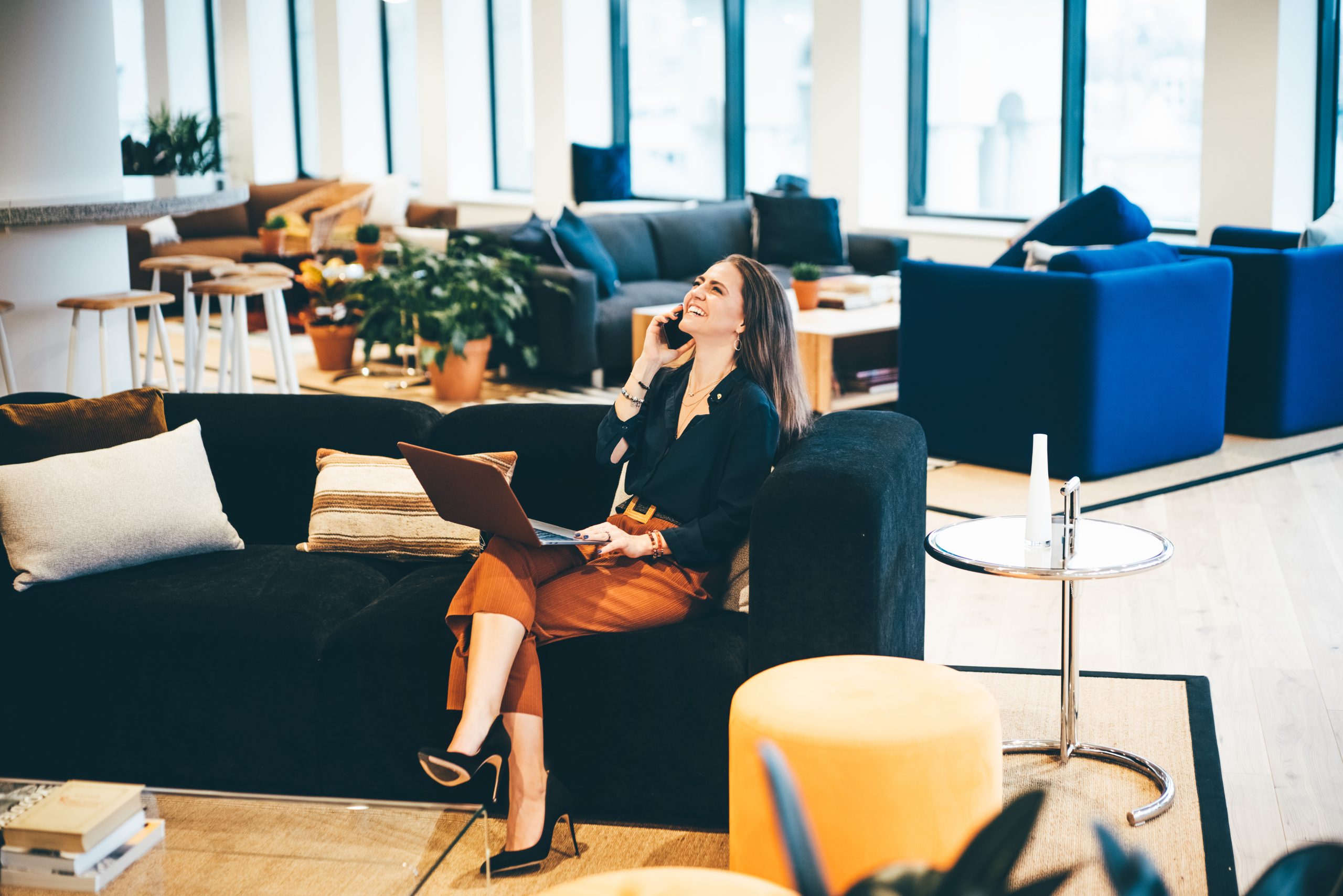 Businesswoman working in coworking. Happy businesswoman talking on the phone in modern Office. Business concept.